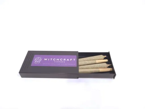 A box with a Witchcraft Cannabis – Pre-Roll Packs and a purple-labeled box from a cheap dispensary near me.