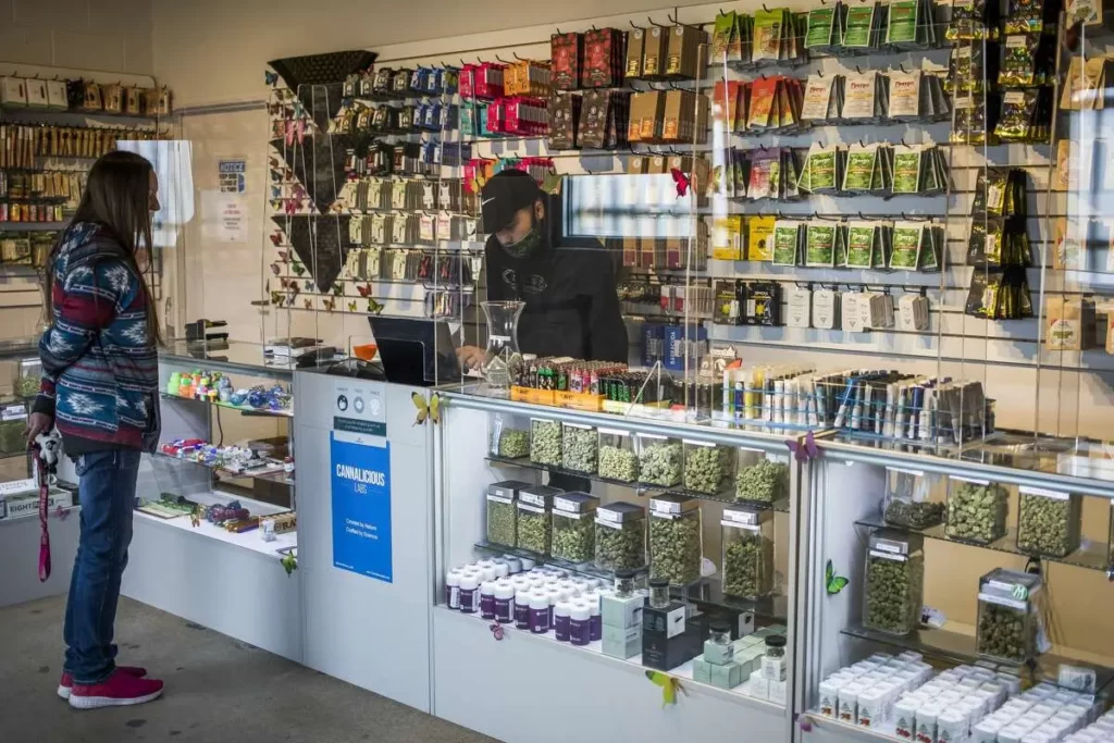 A woman is standing at the counter of a top notch dispensary near me california.